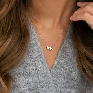 Nahaufnahme einer minimalistischen goldenen Kette mit Herz und dem Buchstaben A.