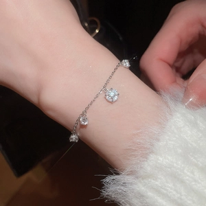 Close-up of elegant silver bracelet with sparkling zircon charms worn on wrist
