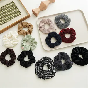 Multiple styles of pleated polyester scrunchies in various colors on cream background