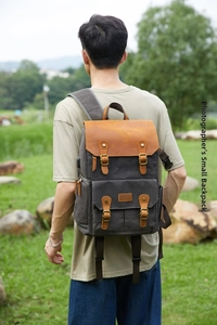 Waterproof vintage camera backpack in grey canvas with brown leather accents on model