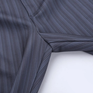 Gros plan sur le tissu à rayures verticales et les coutures du pantalon évasé