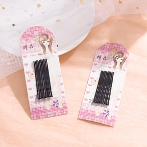 Set of 10 black wavy metal hair pins on a pink illustrated card with golden star mesh decor