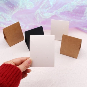 Close-up of white, brown, and black folding jewelry display cards with earring holes