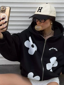 Thick black zip hooded sweatshirt with floral prints and a stylish baseball cap