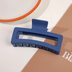Detail shot of a matte navy blue large rectangular hair claw clip for elegant styling