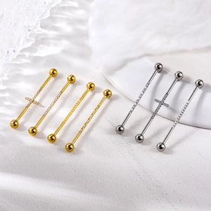 Surgical steel industrial barbell piercings with cross charm and crystal studs on marble