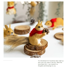 Detail of creative foam squirrel ornament with red scarf and pine cone on wooden stand