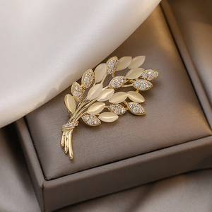 Elegant golden wheat brooch with cat eye stones and rhinestones on premium jewelry case