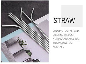 Macro shot of silver stainless steel straight and curved straws on a lifestyle magazine