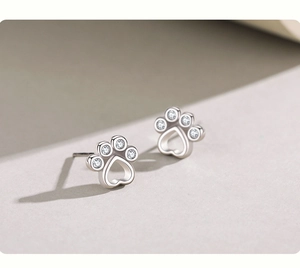 Close-up of paw earrings with heart hollow design and sparkling zircon inlays