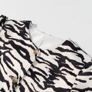 Detail der Zebra-Print Bluse mit Rundhalsausschnitt, Goldknöpfen und Puffärmeln