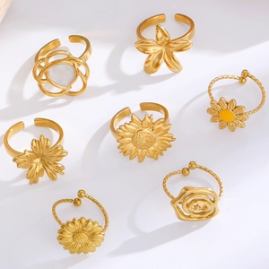 Set of seven gold stainless steel floral rings with sunflower and rose cut-out designs