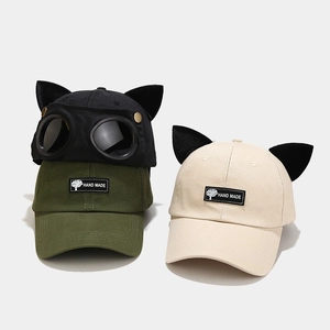 Close-up of cat ears baseball caps with pilot goggles and handmade woven label details