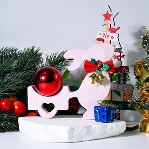 Détail d'un lapin rose poussant un chariot à cœur avec boule rouge et nœud festif