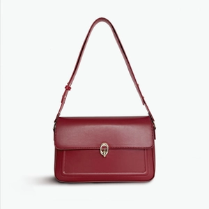 Detailed front view of a burgundy leather flap bag with elegant gold metal clasp