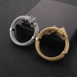Detail of twisted cable bracelets featuring meticulously carved wolf heads in silver and gold