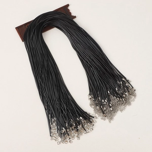 Close-up of black wax cord necklaces with silver metal clasps on a wooden display stand