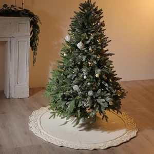 Knitted beige Christmas tree skirt with Aran cable pattern on a wooden floor base