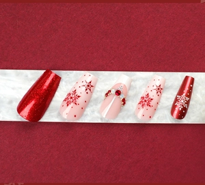 Detail of Christmas coffin nails featuring red glitter and snowflake designs with rhinestones