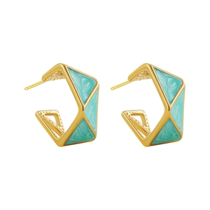 Detail shot of geometric C-shaped gold earrings with turquoise enamel and marble pattern