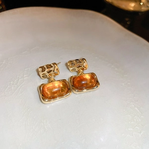 Detailed close-up of vintage resin square stud earrings with textured gold plating
