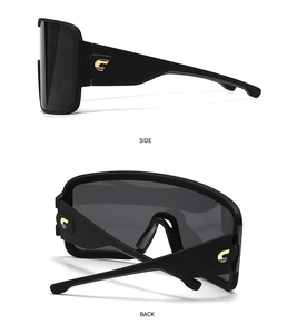 Detail view of oversized mask sunglasses showing side profile and gold hinge accents