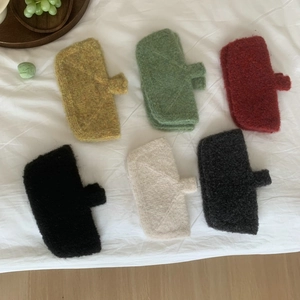 Detailed overhead view of multi-colored knitted phone pouches with small handles