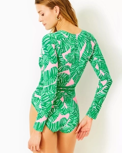 Detail of long-sleeve floral surfboard swimsuit with tropical green palm leaf print