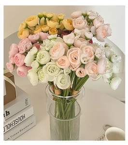 Close-up of multicolored artificial eustoma flowers in a clear glass vase for home decor