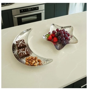 Detailed close-up of crescent and star shaped metal trays with hammered texture and food