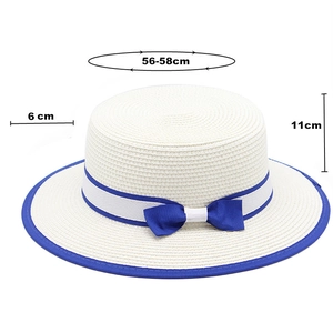 Close-up of white boater hat with blue ribbon bow, 6cm brim and 56-58cm head size