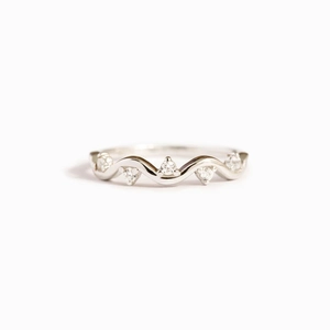 Detailed close-up of wavy silver band ring featuring five sparkling zircon stones