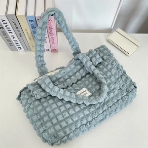 Macro shot of light blue bubble textured tote bag with ozakka studio brand tag