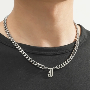 Close-up of stainless steel Cuban chain necklace with letter J pendant worn by a model