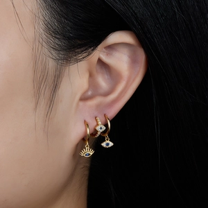 Three-piece set of golden Evil Eye hoop earrings with blue stones and white zircon details