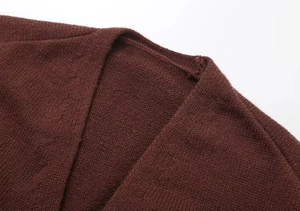 Detailed view of dark brown knitted cardigan featuring a V-neckline and precise stitching