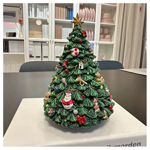 Close-up of resin Christmas tree music box with hand-painted Santa and gingerbread ornaments