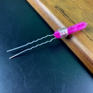 Detail of pink crystal hair fork with silver wire wrapping on wavy metal pins