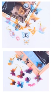 Détail macro de boucles d'oreilles papillon en résine avec effet dégradé pailleté