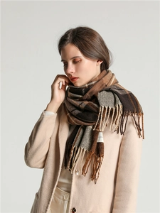 Close-up of brown plaid scarf with soft texture and stylish fringes on a model