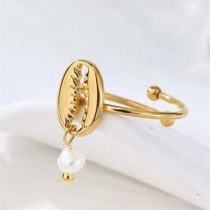 Detail of 18k gold open ring featuring a shell design and white teardrop pearl pendant