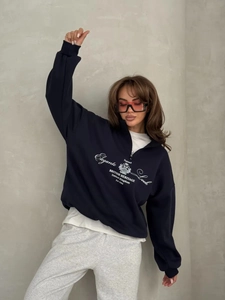 Detail of dark blue half-zip sweatshirt with British Heritage print and stand collar