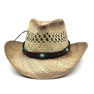 Detail of western straw hat featuring a brown leather band with turquoise turquoise accents