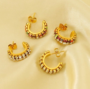 Detailed flat lay of C-shaped gold-plated hoop earrings with clear and colorful zircon