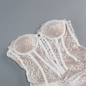 Détail d'un haut corset en dentelle blanche avec ruban lacé et texture maille