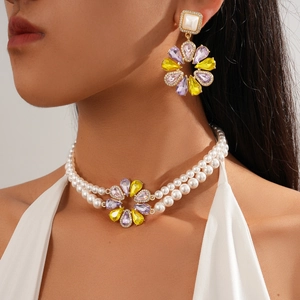 Detail of double-layer pearl necklace and flower earrings with colorful crystals