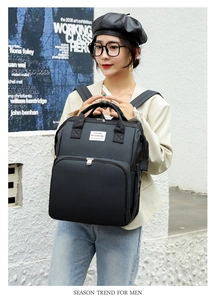 Close-up of black multifunctional diaper backpack featuring multiple storage pockets