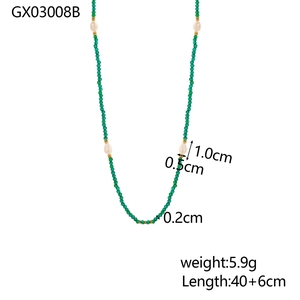 Macro detail of handmade necklace featuring green crystal beads and white freshwater pearls