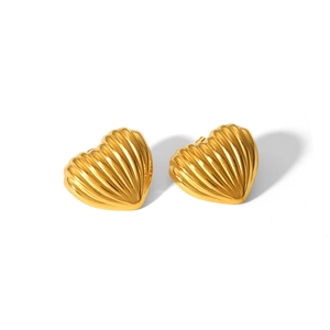 Macro detail of 18k gold heart studs with intricate linear textured surface finish