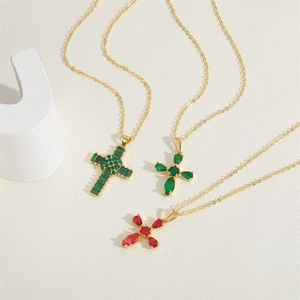 Three vintage cross necklaces with colorful zircon stones on gold chains in a still life view